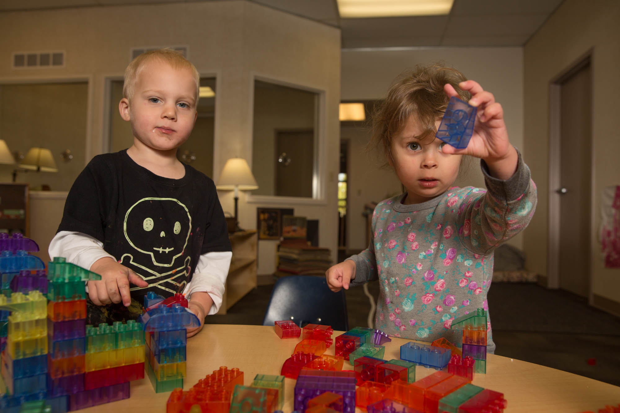 A baby boy and girl playing with blocks