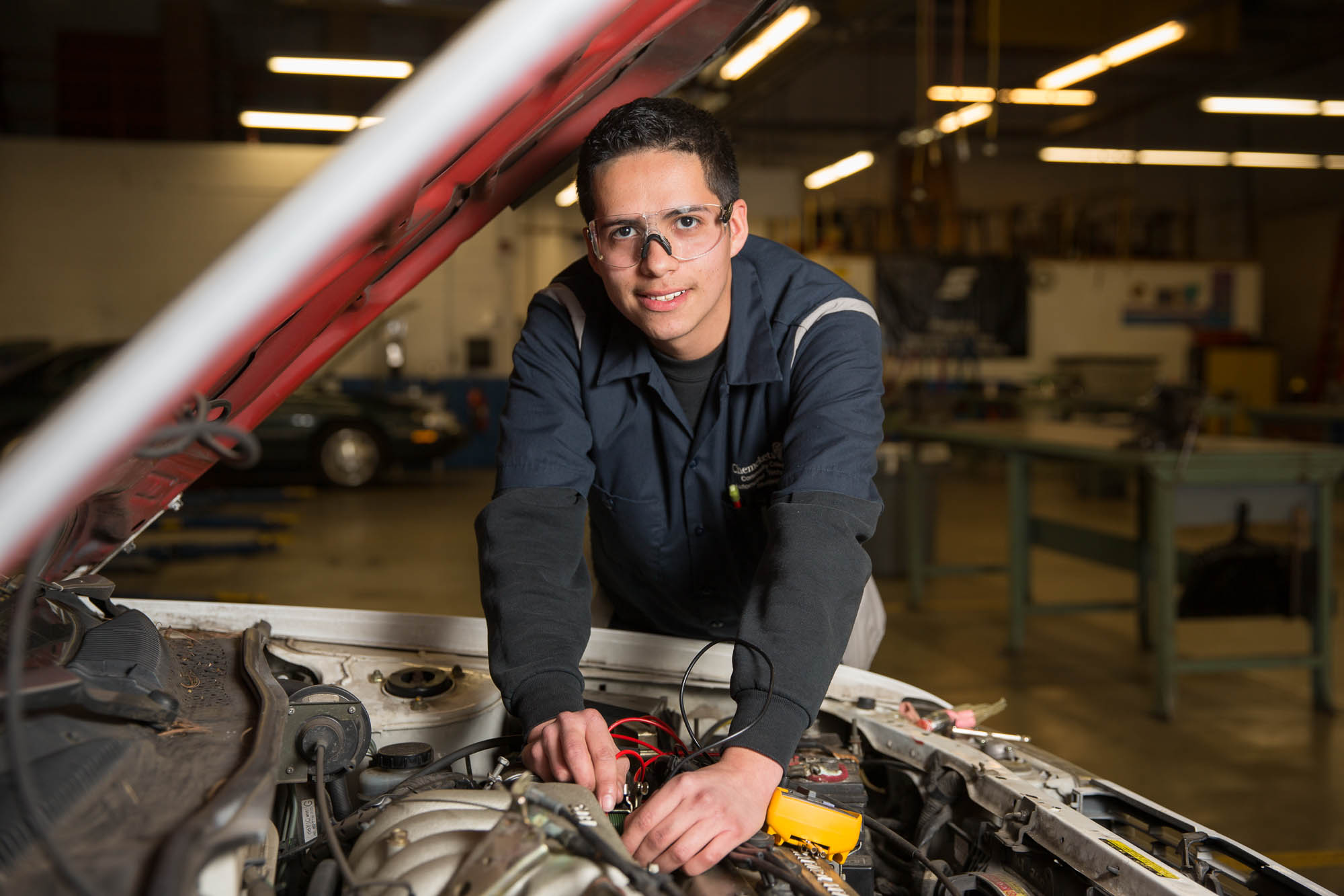 A student working under the hood of the car
