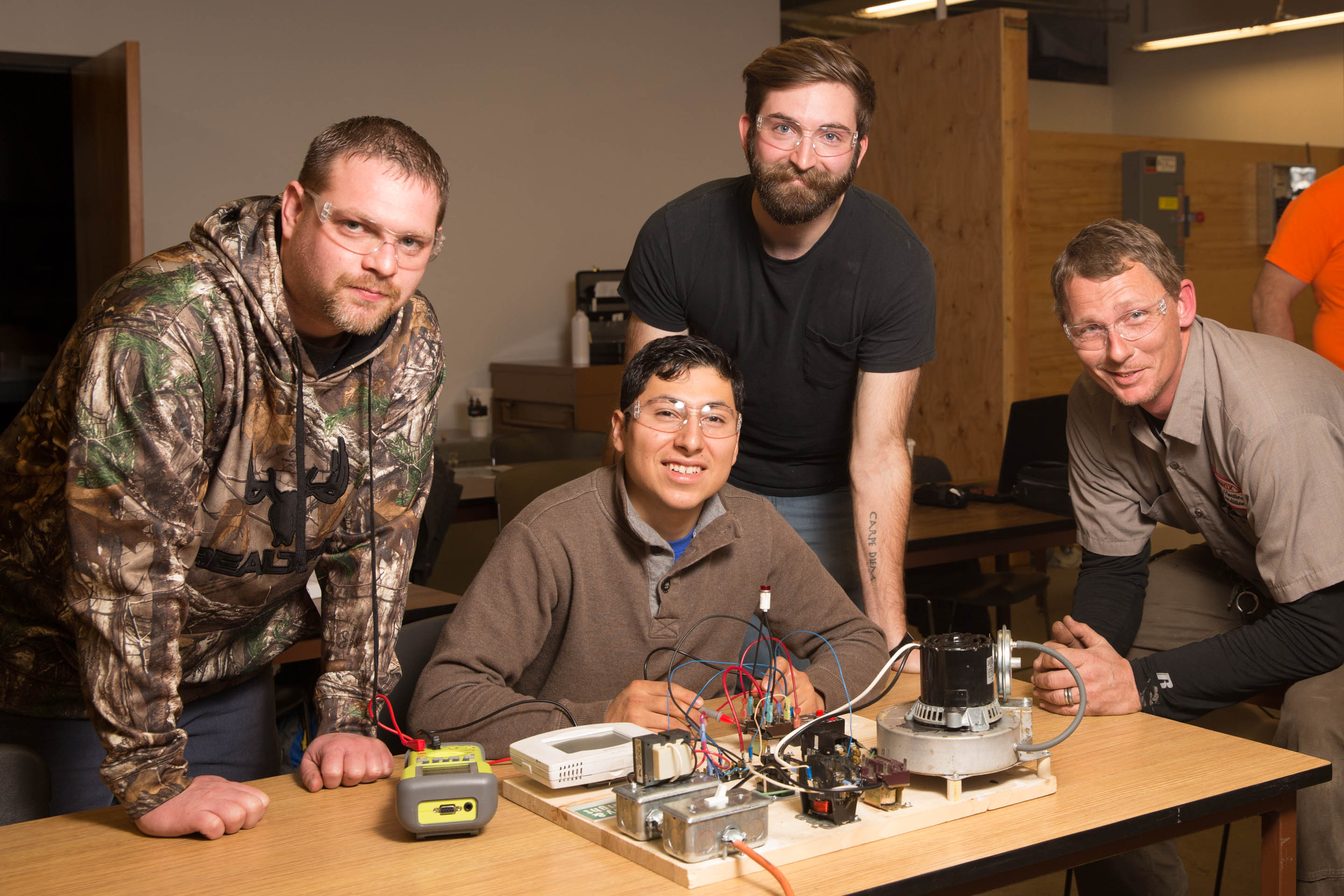 Four men working on electrical systems
